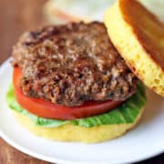 Bison burger in a bun with lettuce and tomato.