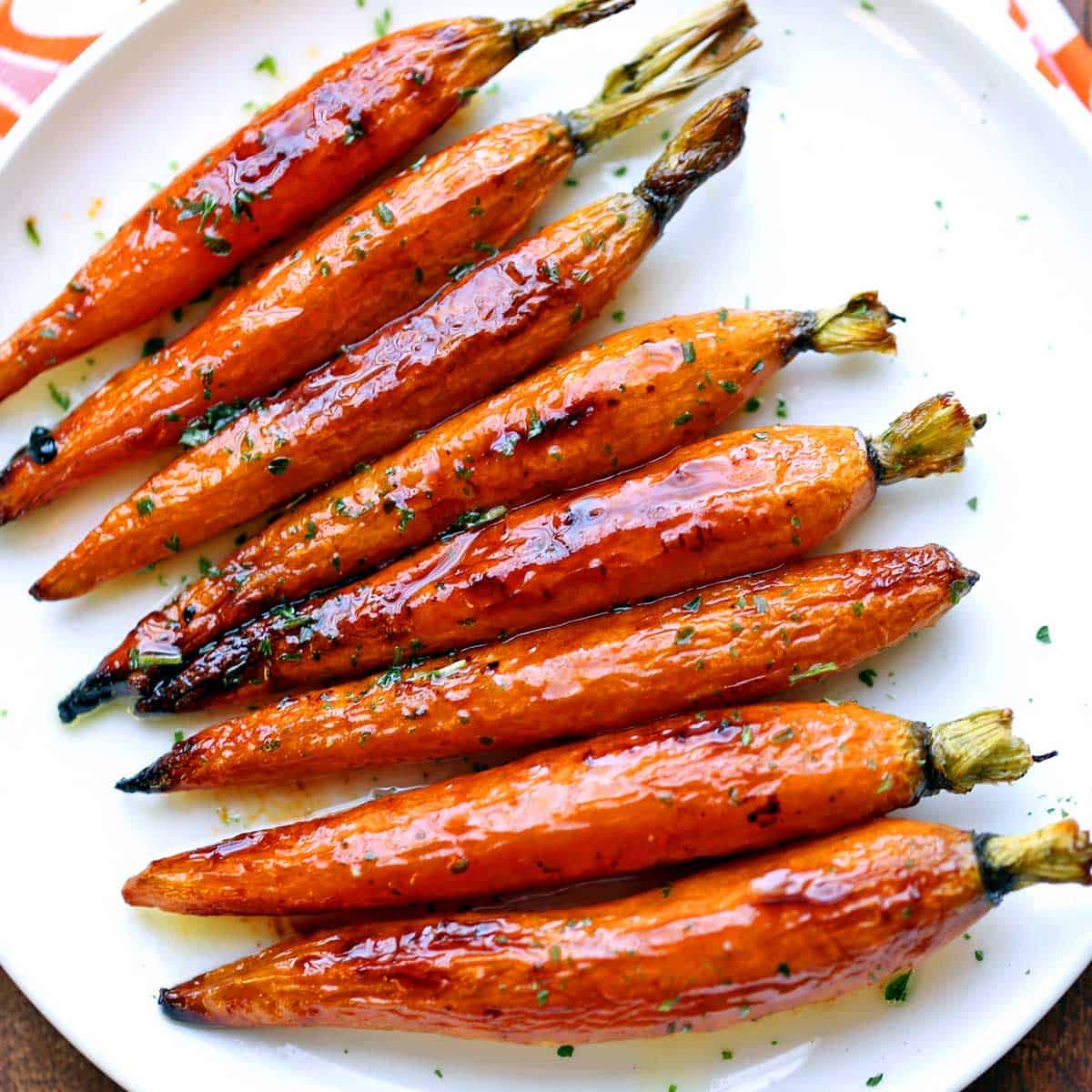 Roasted carrots served on a white plate.