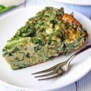 Spinach frittata served on a white plate with a fork.