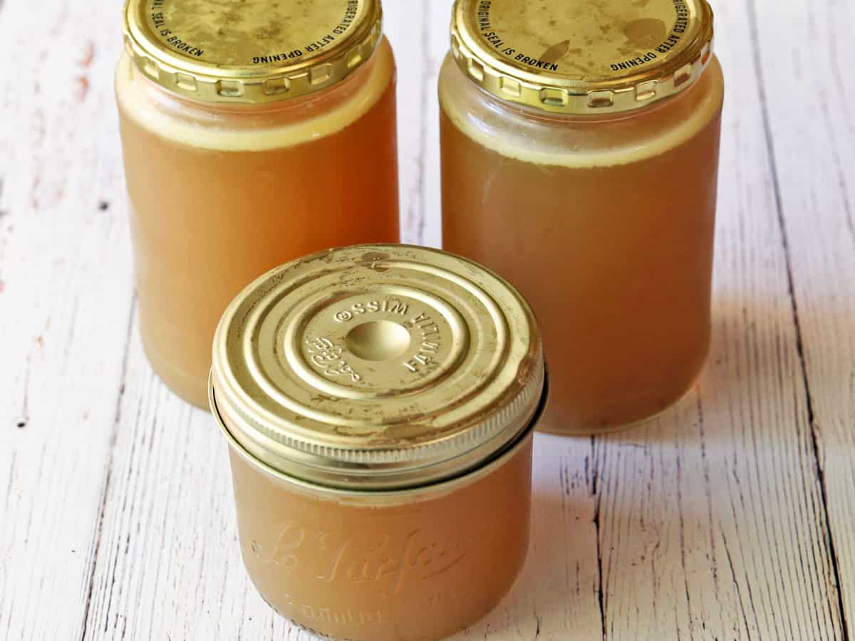 Chicken broth in jars. The fat layer is visible on the top. 