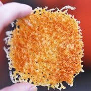 A keto cheese cracker held up in the air.