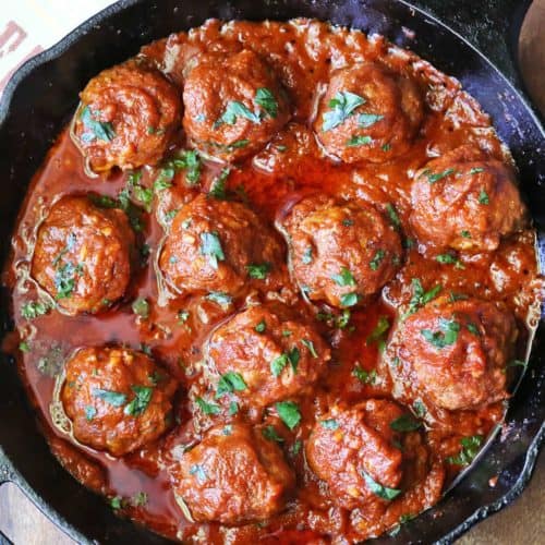 Meatballs with tomato sauce served in a cast-iron skillet.