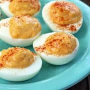 Spicy deviled eggs served on a light-blue plate.