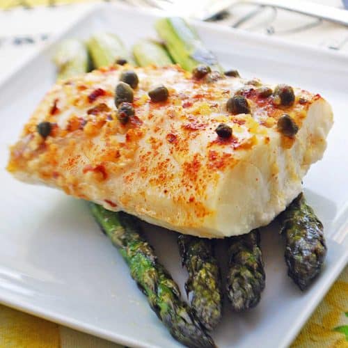 Baked cod is served on top of asparagus.