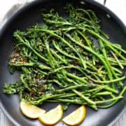 Sauteed broccolini served with lemon slices.