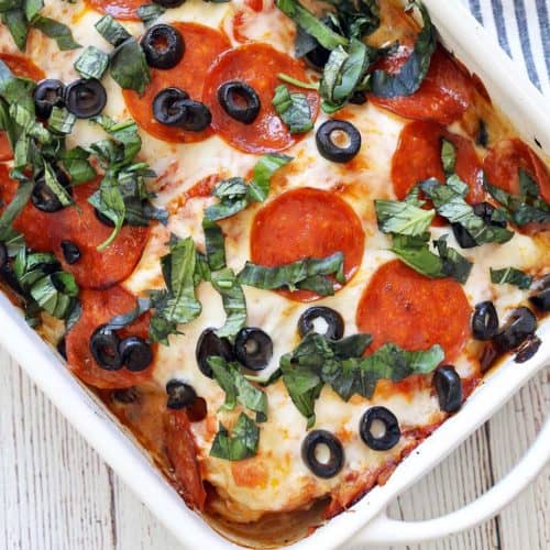 Pizza chicken served in a white baking dish with a striped napkin.