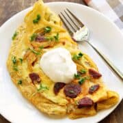 Chorizo omelette topped with sour cream.