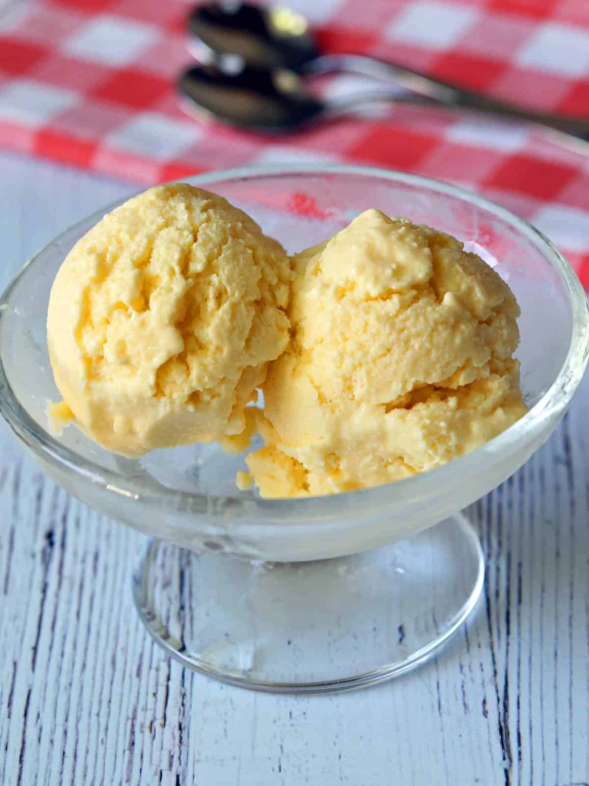 Yogur helado de mango servido en un tazón de postre de vidrio. 