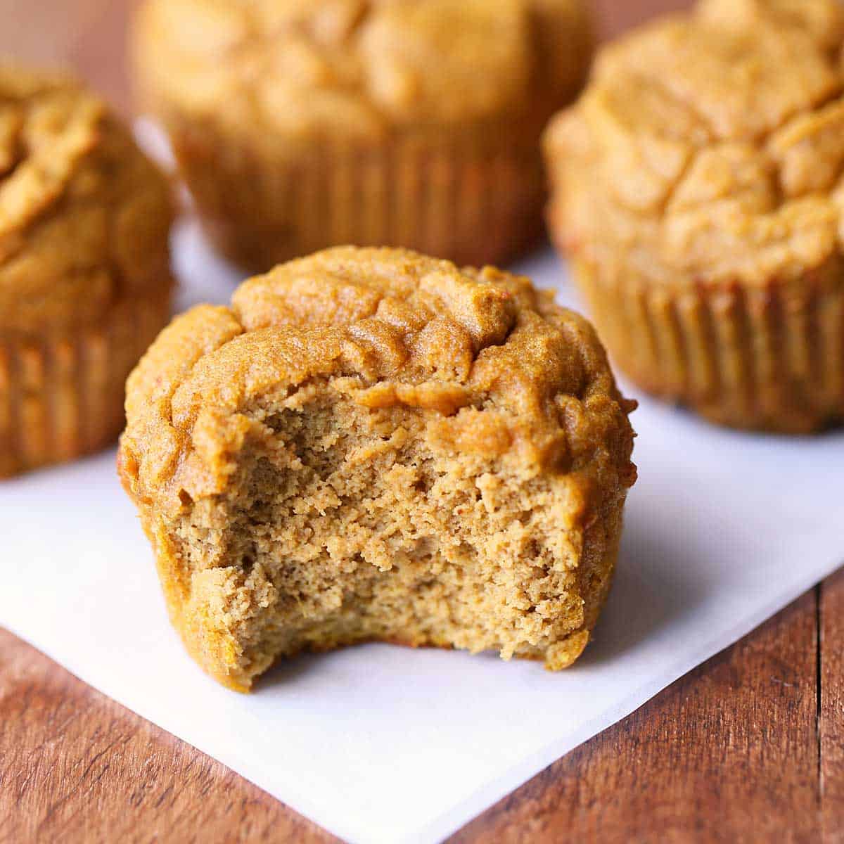 Keto pumpkin muffins served on a square of parchment paper.