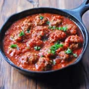 Spicy meatballs served in a cast-iron skillet.