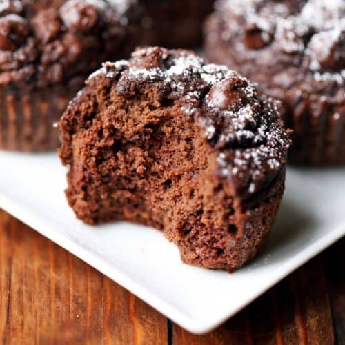 Keto chocolate muffins with a bite taken from one of them.