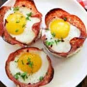 Salami and egg cups served on a white plate.