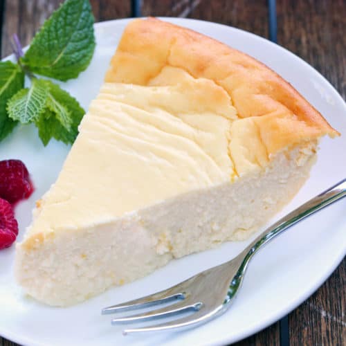 Ricotta cheesecake served on a white plate with a fork.