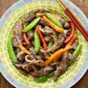 Steak stir-fry served on a Chinese-style plate.