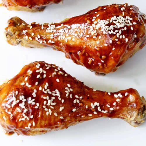 Teriyaki chicken drumsticks topped with sesame seeds.