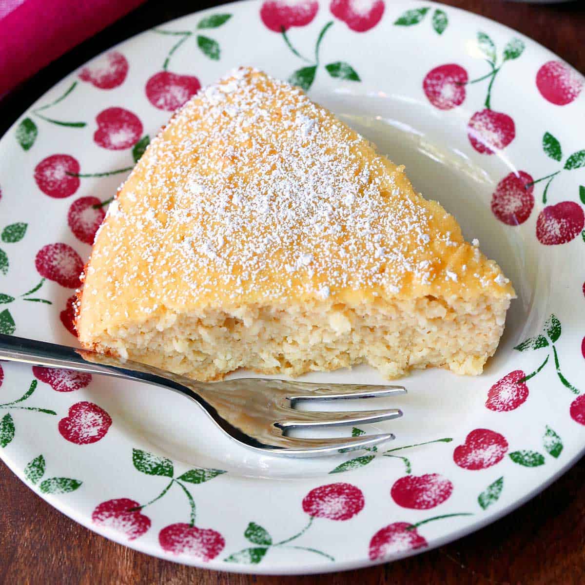 Keto coconut cake served on a plate with a fork.