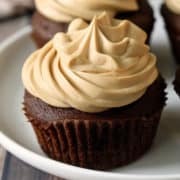 Keto chocolate cupcakes topped with frosting.