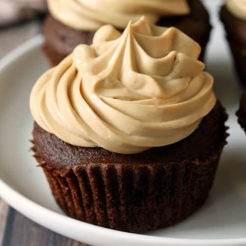 Keto chocolate cupcakes topped with frosting.
