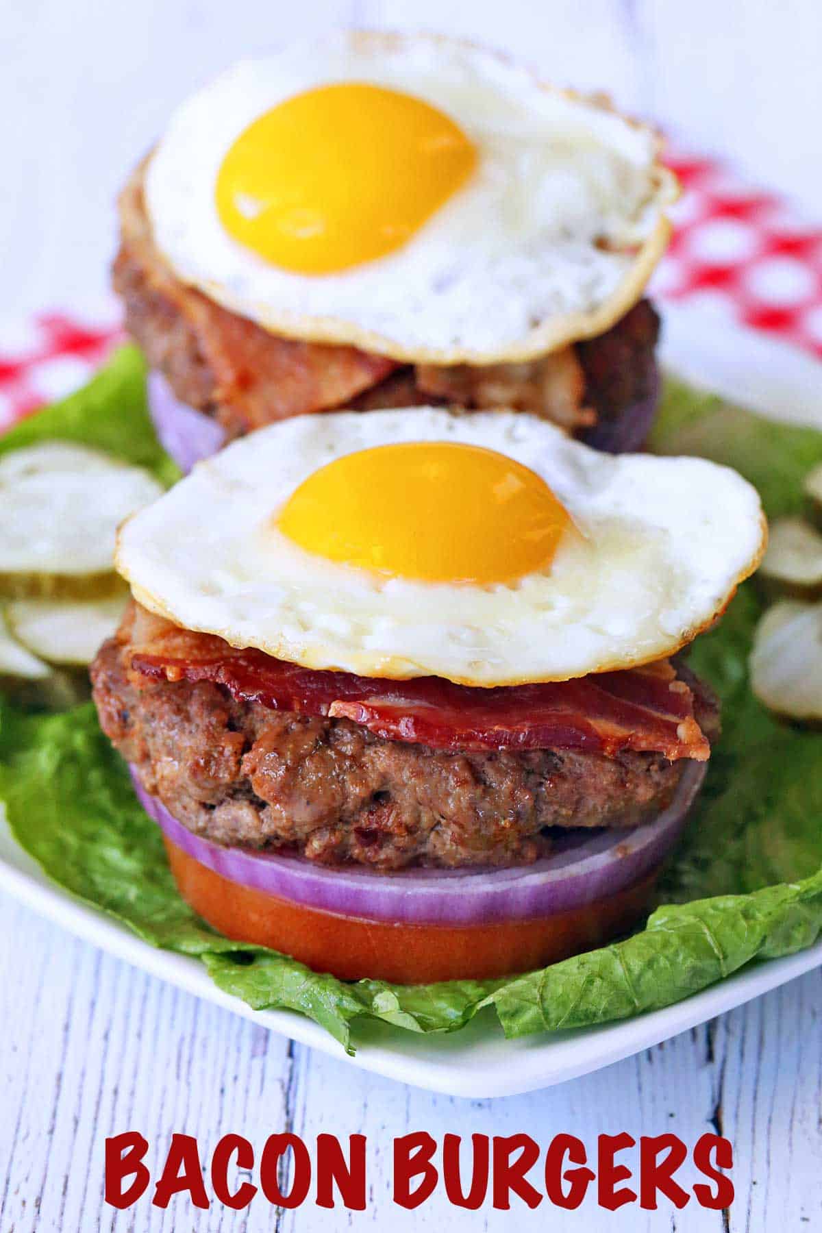 Two bacon burgers topped with eggs.