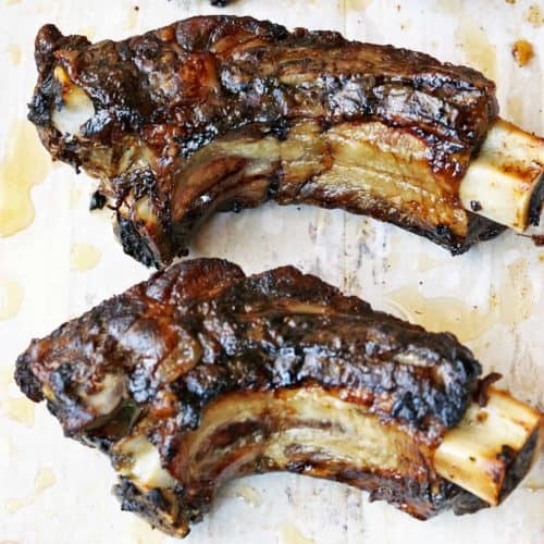 Beef back ribs on a parchment-lined baking sheet.