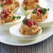 Bacon deviled eggs served on a white plate.