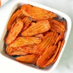 Carrot chips are served in a white bowl.