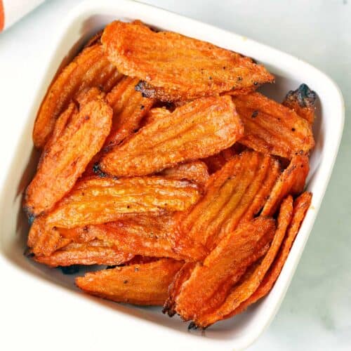 Carrot chips served in a white bowl.