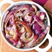 Roasted red onions served in a white bowl.