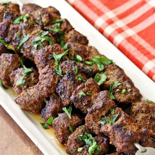Beef kabobs topped with chopped parsley.