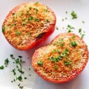 Broiled tomatoes topped with chopped parsley.