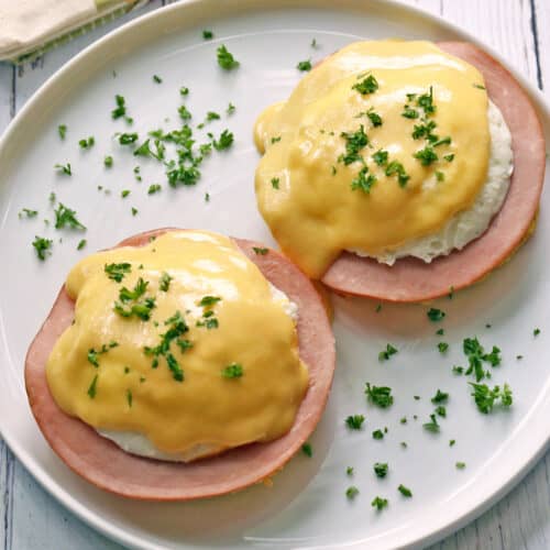 Keto eggs benedict served on a white plate with a napkin.