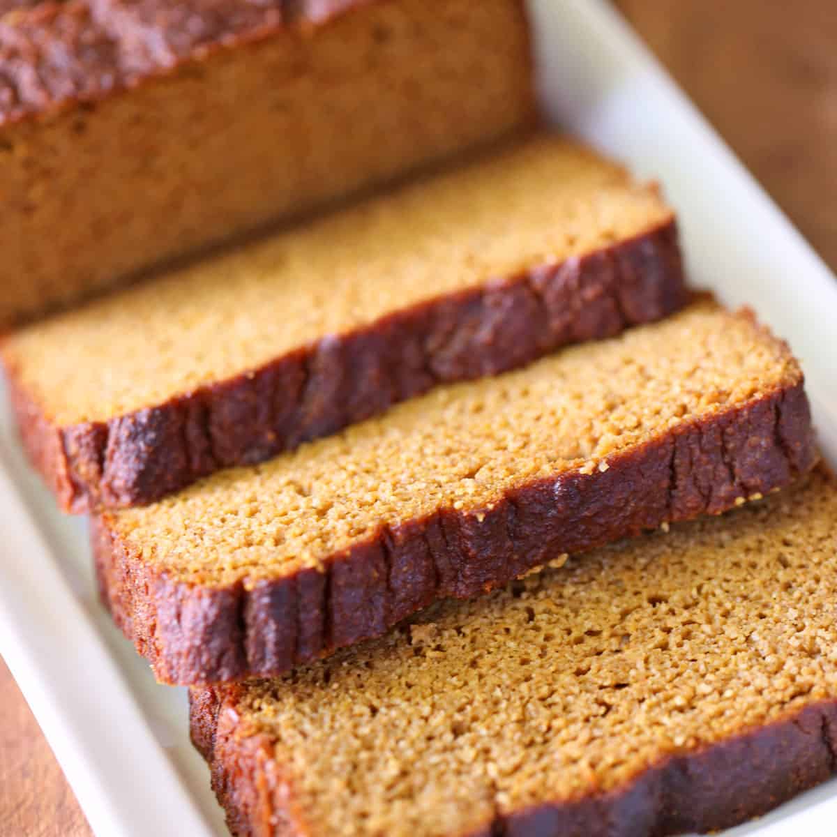 Keto pumpkin bread, sliced, served on a white tray.