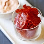 Salami chips served with a dip.