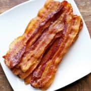 Oven bacon served on a white plate.