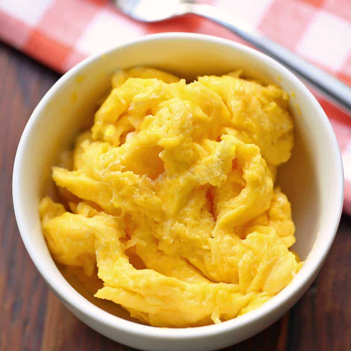 Microwave scrambled eggs served in a white bowl.