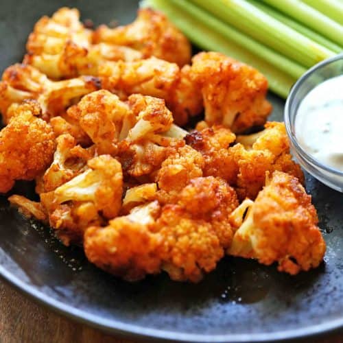 Buffalo cauliflower wings served with celery and a dipping sauce.