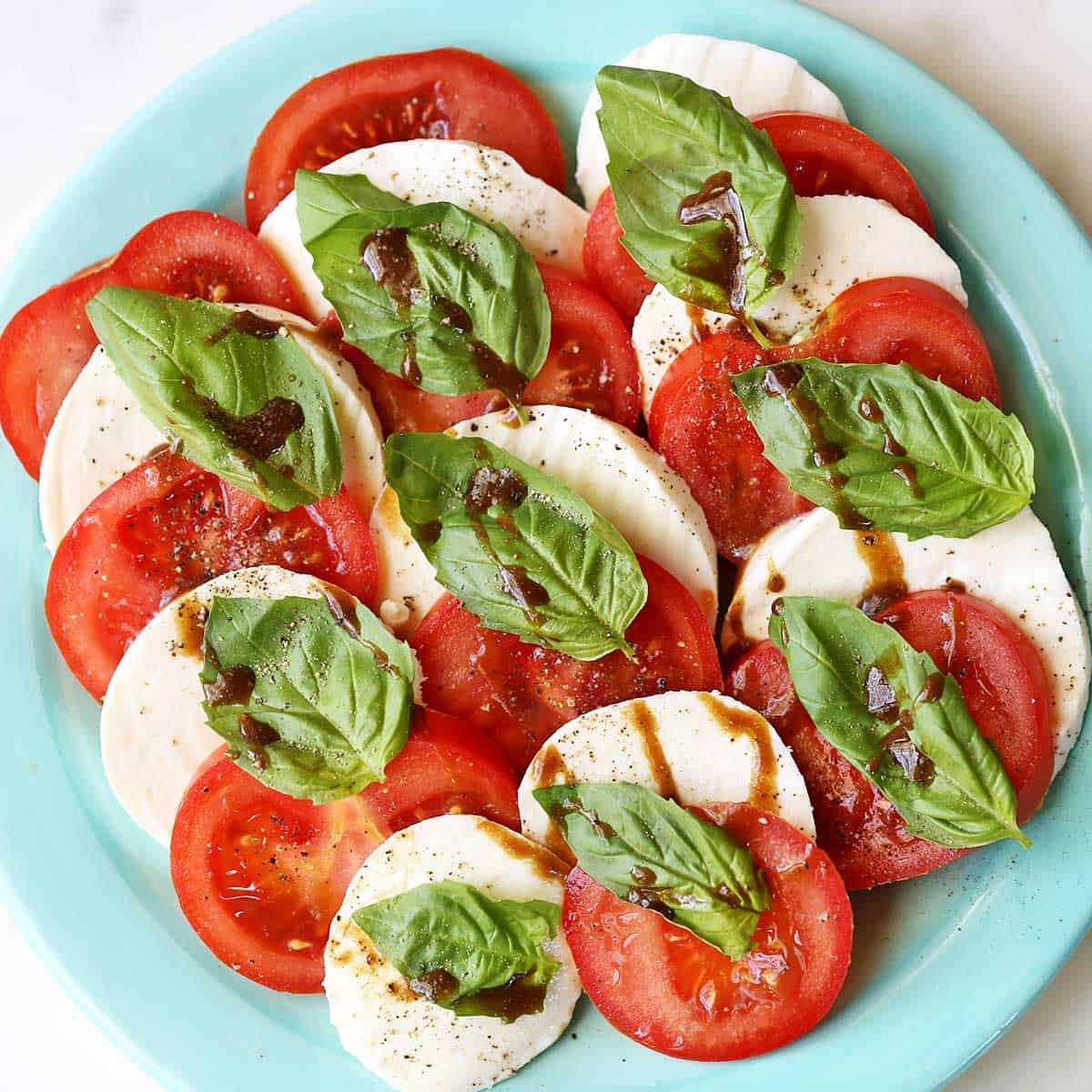 Caprese salad served on a light-blue plate.