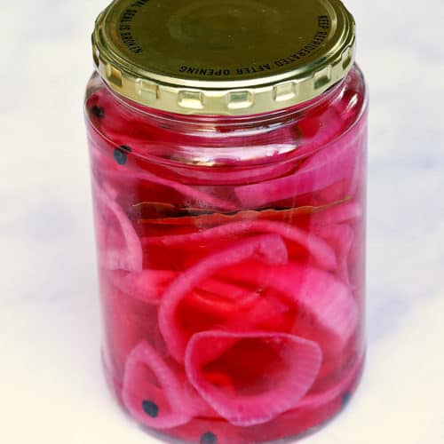Pickled red onions in a sealed jar.