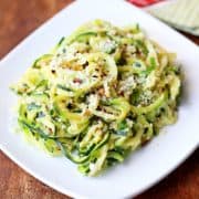 Zucchini noodles piled on a white plate.