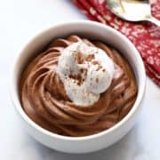 Keto chocolate mousse topped with whipped cream.