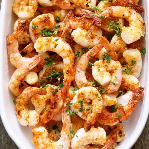 Baked shrimp are served in a white dish.