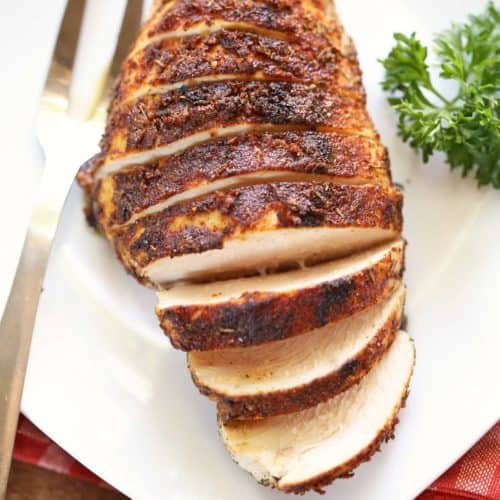 Blackened chicken, sliced, served with a fork.