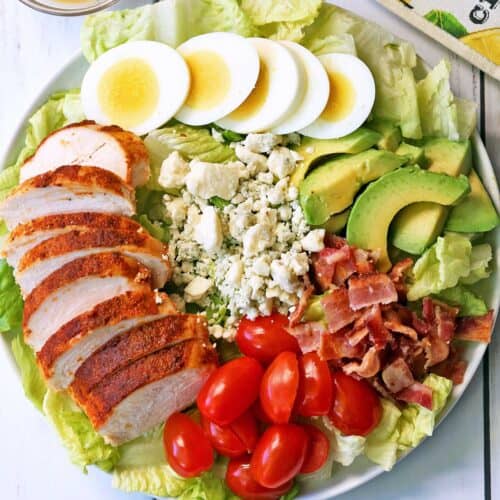 Chicken Cobb salad served on a white plate.