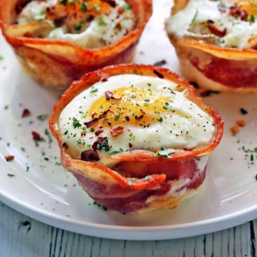 Bacon egg cups served on a white plate.