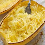 Baked spaghetti squash served on a baking sheet with a fork.