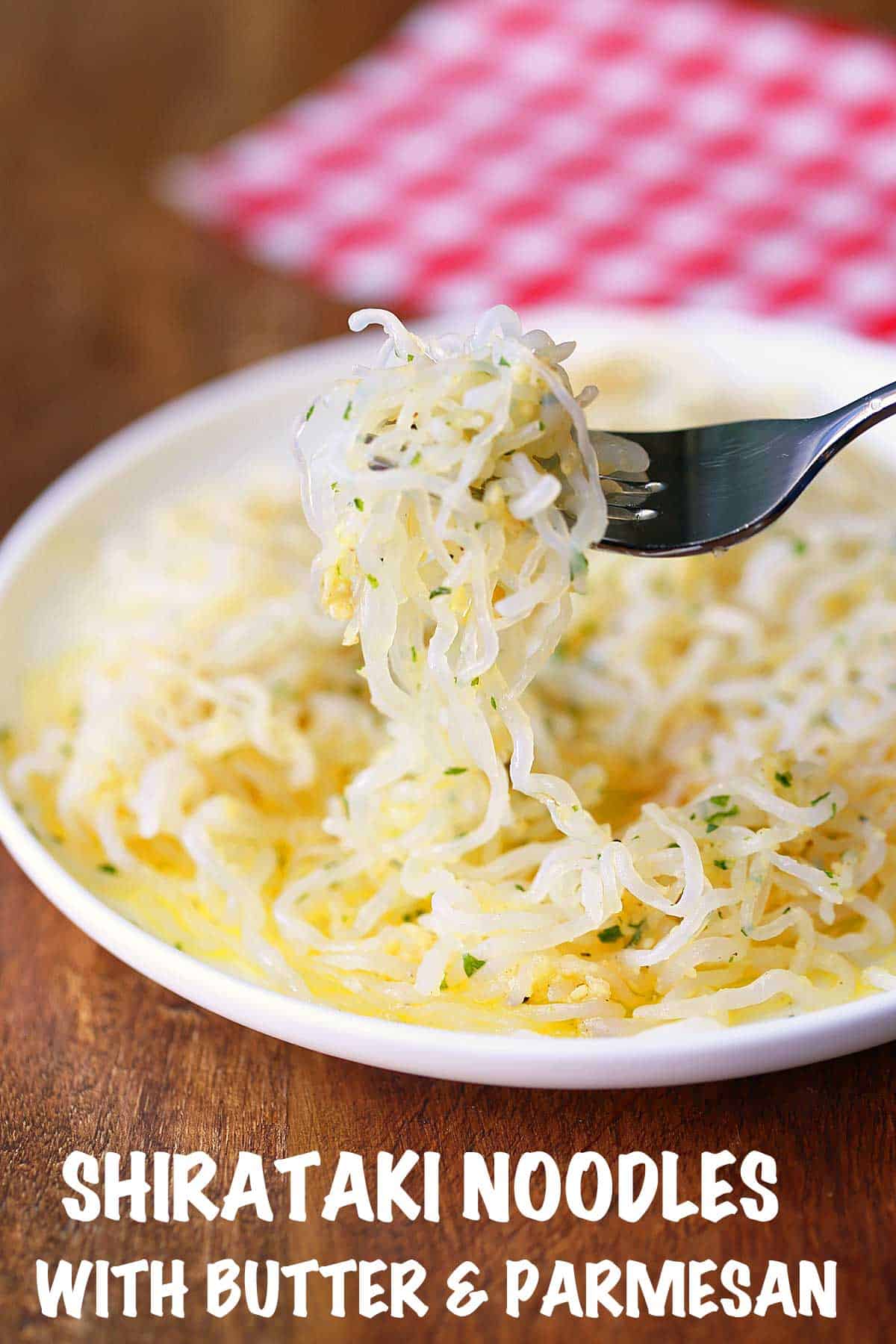 Shirataki noodles with butter and parmesan, served on a white plate with a fork. 