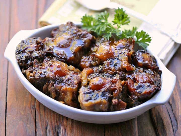 Slow cooker oxtail in a white serving dish. 