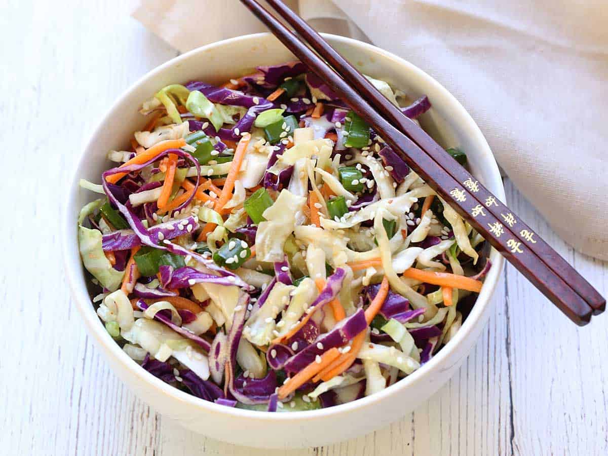 Asian cabbage salad served in a bowl with chopsticks.