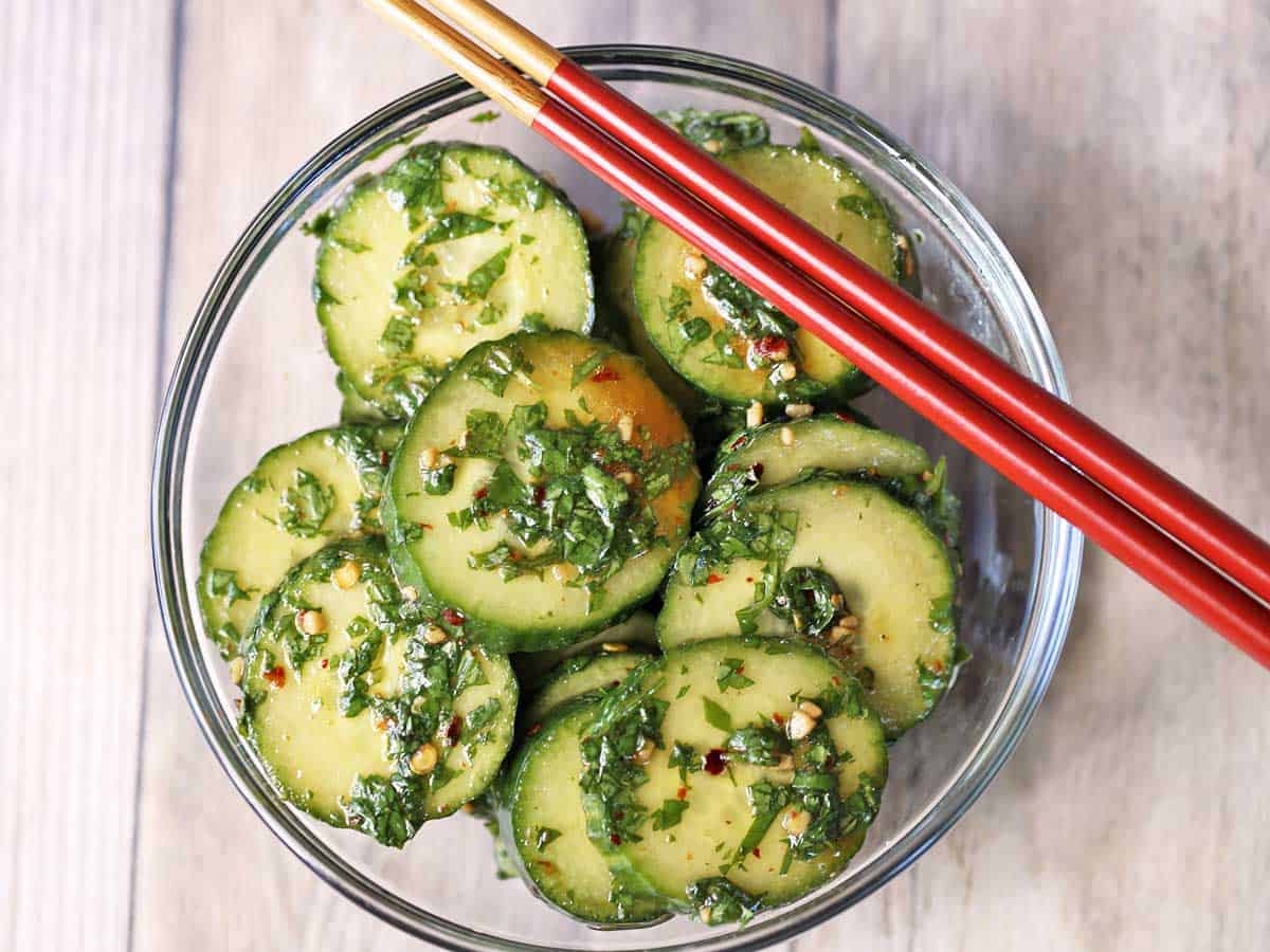 Asian cucumber salad served in a bowl with chopsticks. 