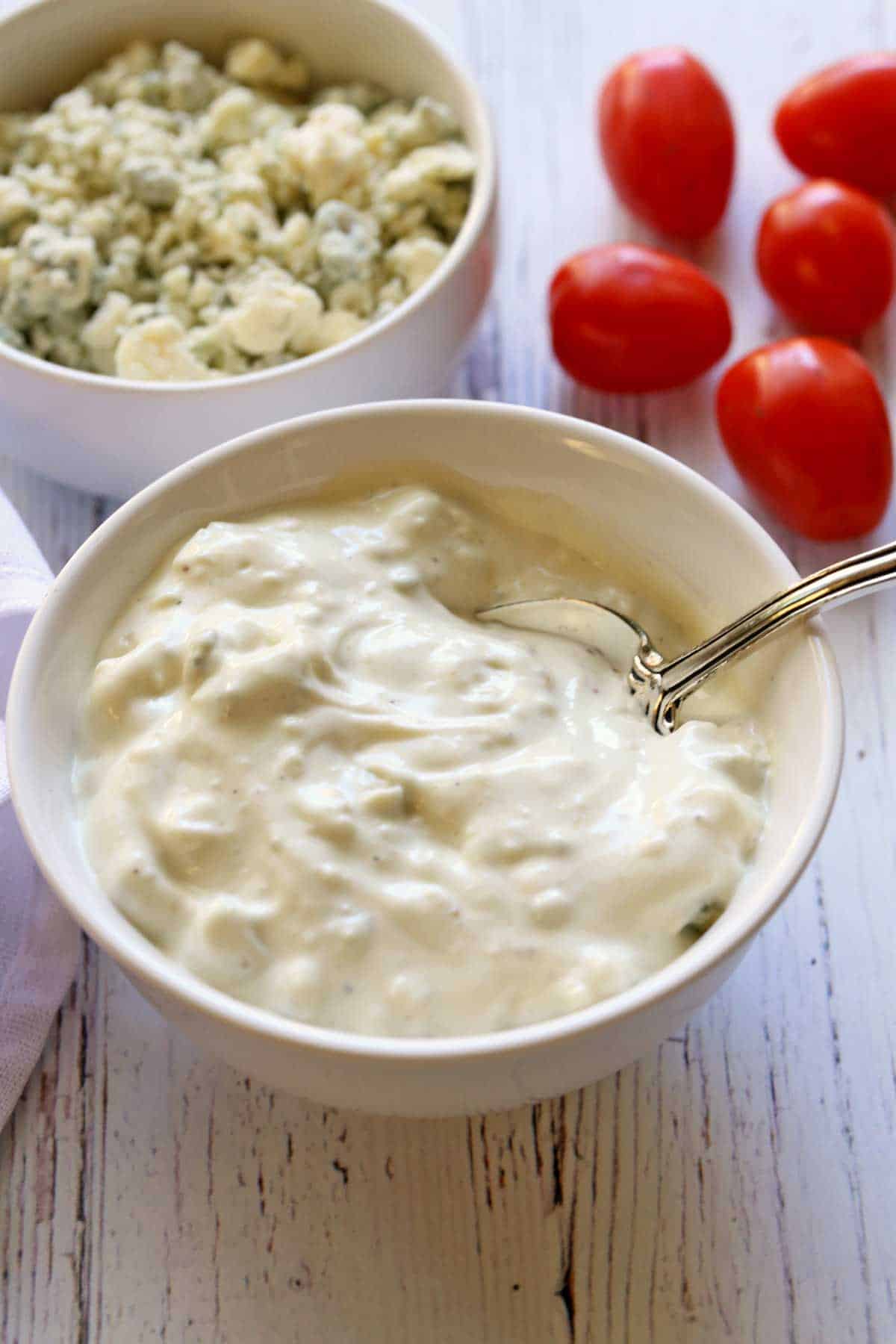 Homemade blue cheese dressing served in a bowl with a spoon.
